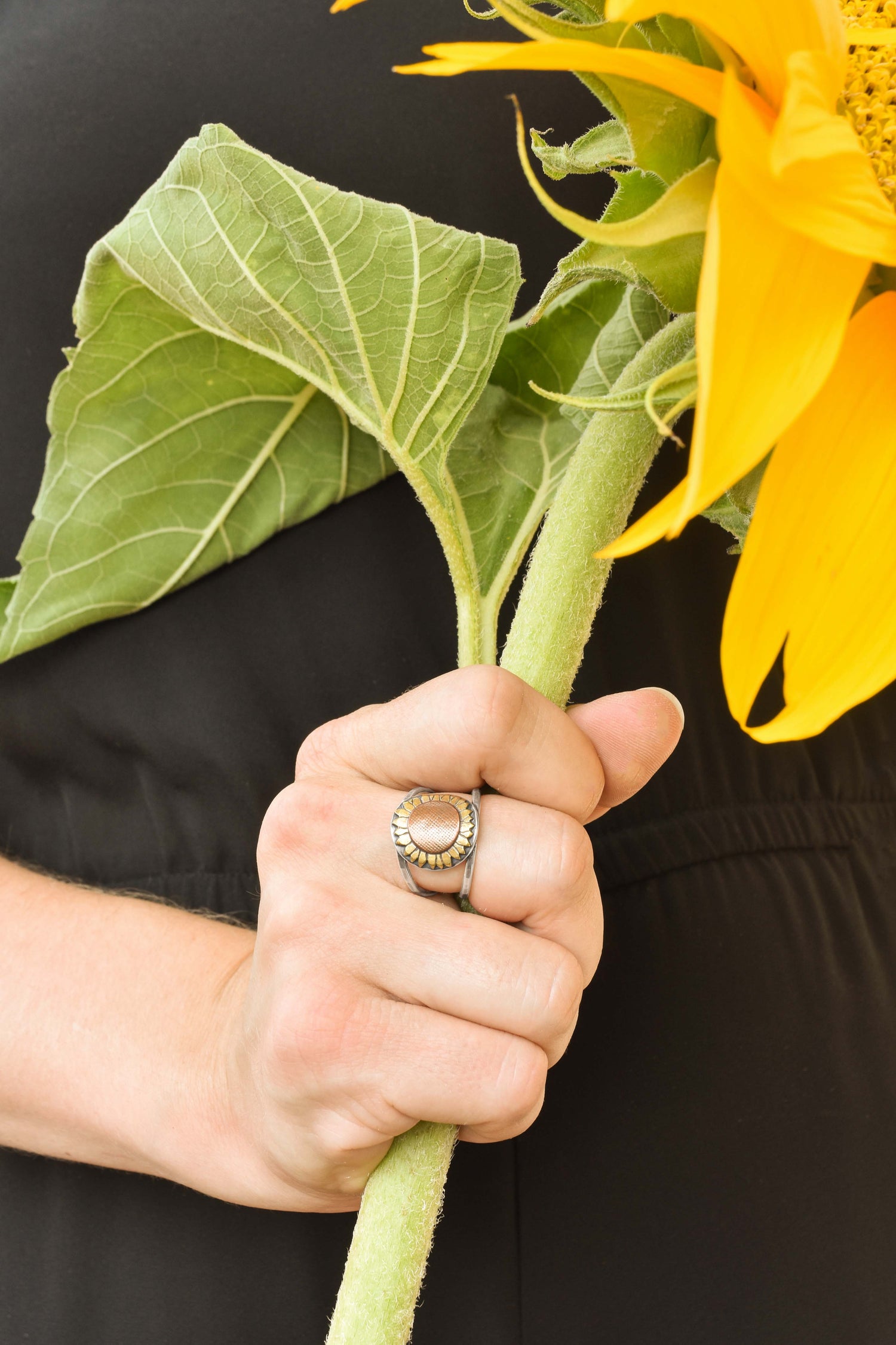 Sunflower RIng in Sterling Silver Copper and Brass made at Beth Millner Jewelry on model holding sunflower