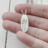 Oval sterling silver pendant with copper cattails. By Beth Millner Jewelry. 