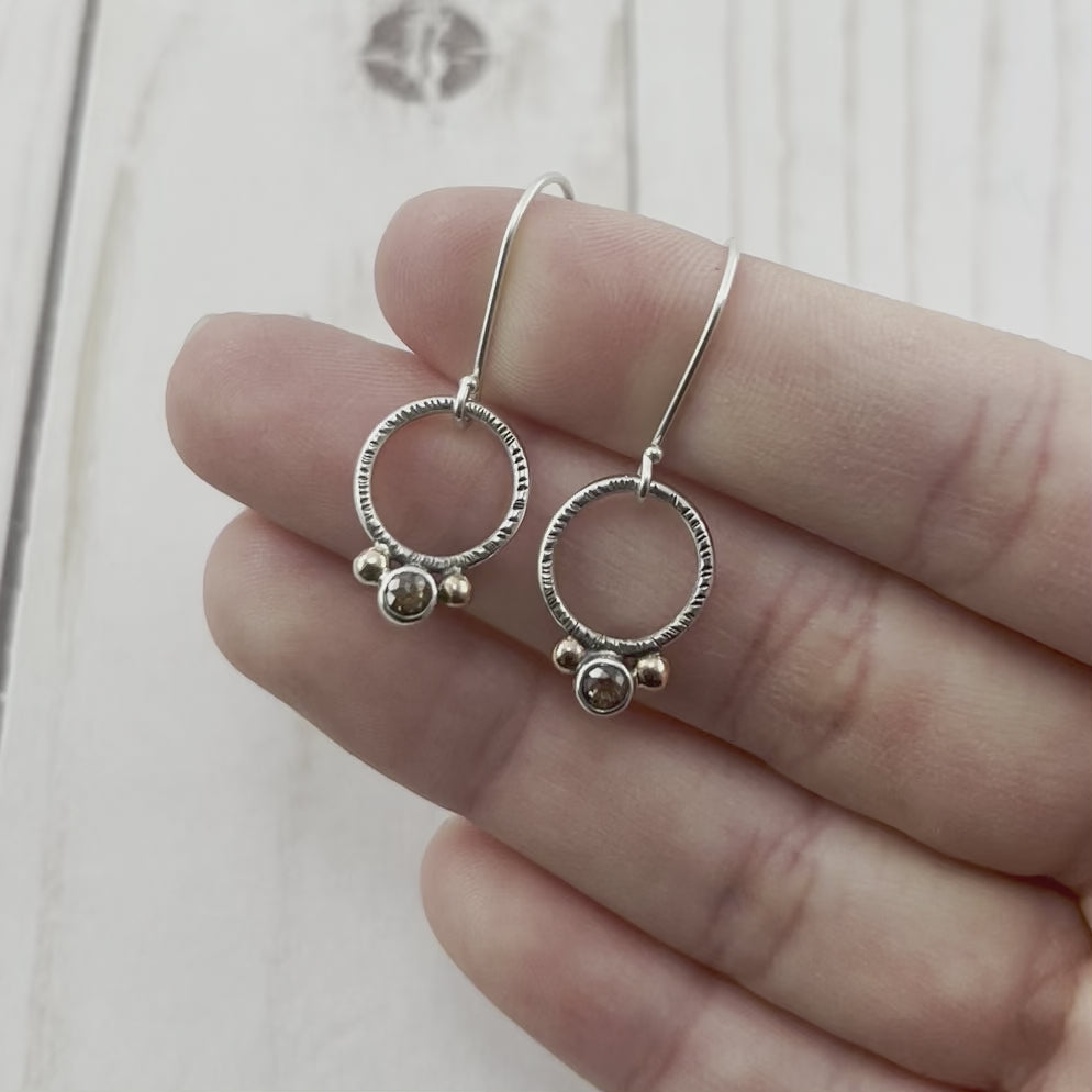 Round sterling silver hoop earrings featuring rustic diamonds and rose gold drops. By Beth Millner Jewelry.