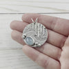 Round Sterling Silver Pendant featuring aquamarine and water, icicle, and pebble details. By Beth Millner Jewelry. 