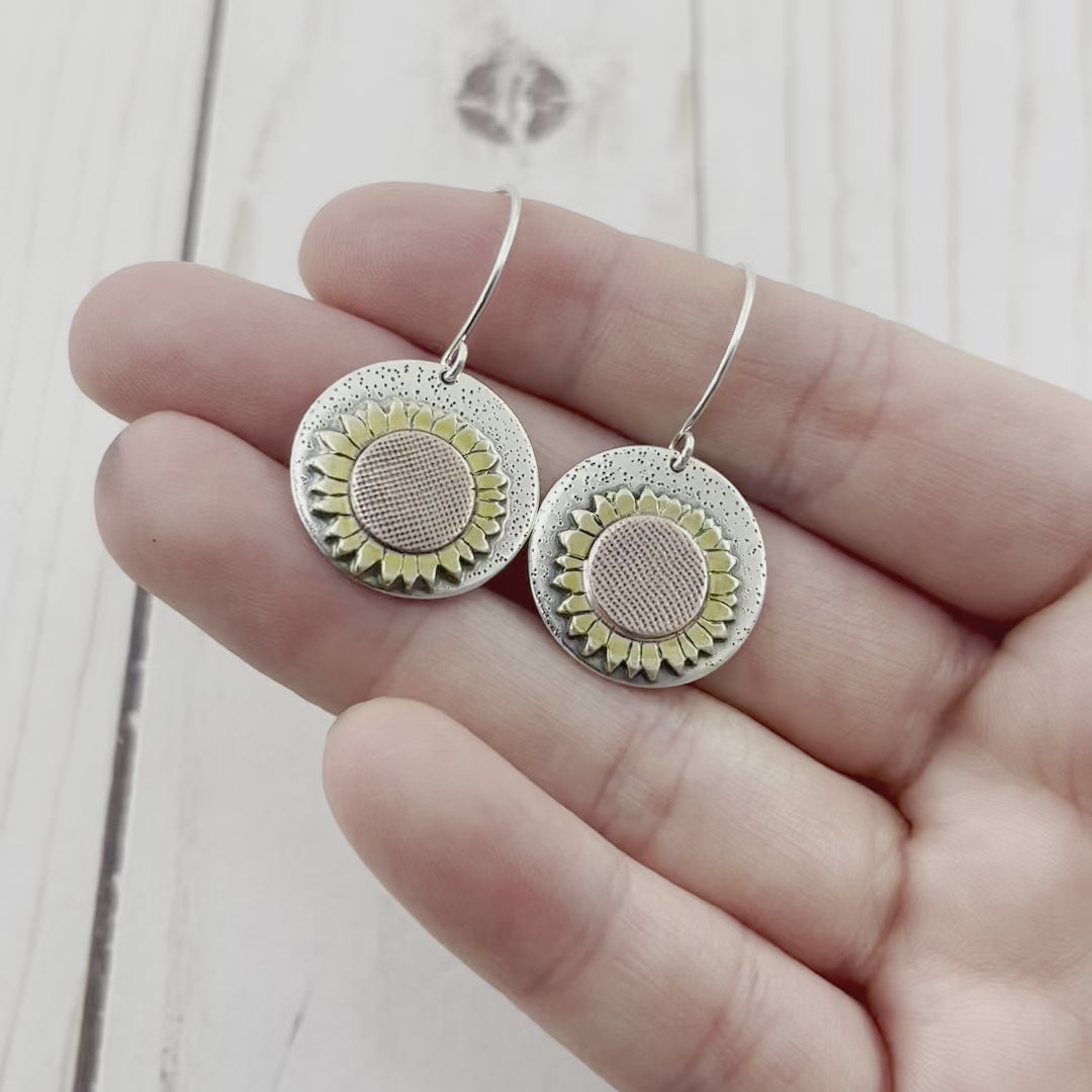 Round sterling silver earrings with a copper and brass sunflower. silhouette
