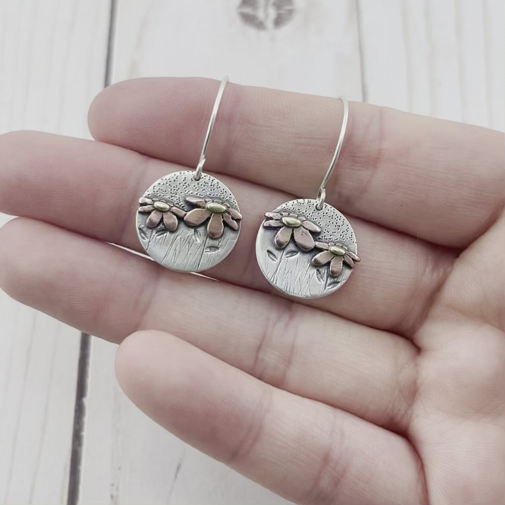 Round sterling silver earrings with copper and brass wildflowers. silhouette