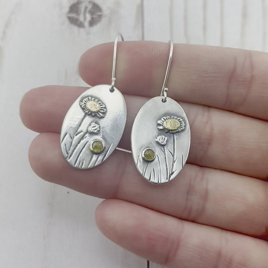 Oval sterling silver earrings featuring a daisy with a yellow gold center and rustic diamond. By Beth Millner Jewelry.