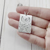 Rectangle sterling silver pendant featuring a crane and cattails. By Beth Millner jewelry.
