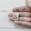 Rectangle sterling silver mixed metal pendant with a brass and copper layered landscape and hand sawn trees. Handmade by Beth Millner Jewelry